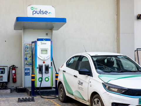 Delhi, India - 28th Mar 2026: An electric Uber cab charges at a public Jio BP Pulse EV station in Delhi, highlighting sustainable transport, clean energy adoption, and urban mobility infrastructure in