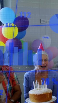 Vertical video: Camera panning, seniors celebrating birthday while overlay showing business charts
