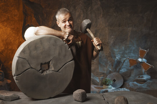 Proud prehistoric man inventing the first wheel
