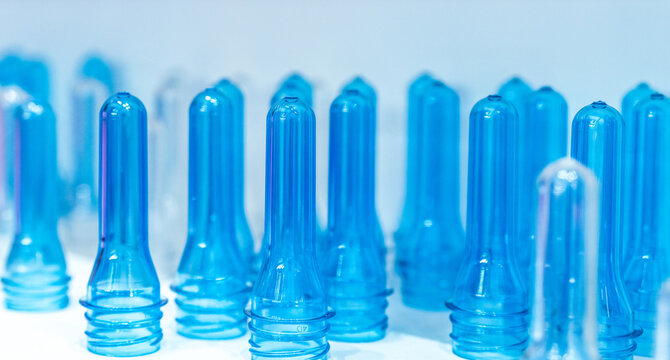 PET plastic bottle preforms before blow molding. Packaging industry. PET preforms from preforms injection molding machine. Raw material for PET bottle. Recycle plastic. Polyethylene terephthalate.