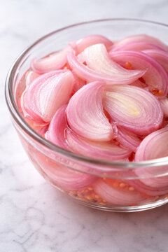 Pickled shallot slices in a glass bowl for healthy side dish preparation and culinary garnish concepts.