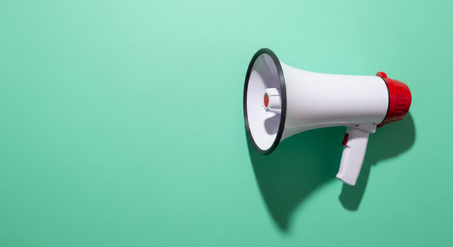 White and red megaphone isolated on a green studio background perfect for public marketing announcements