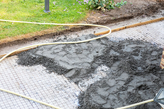 Pouring concrete over reinforcement mesh for slab foundation