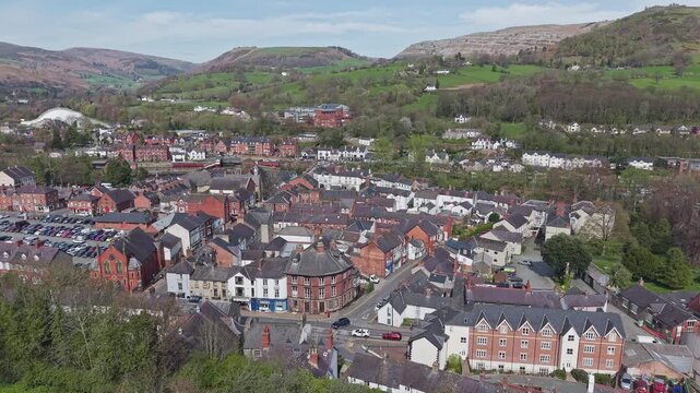 Aerial view shows the historic stone buildings of Llangollen town centre within the scenic landscape of North Wales