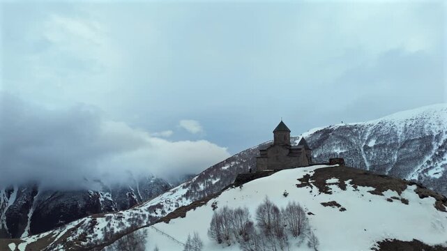 Ancient church on mountain ridge in clouds