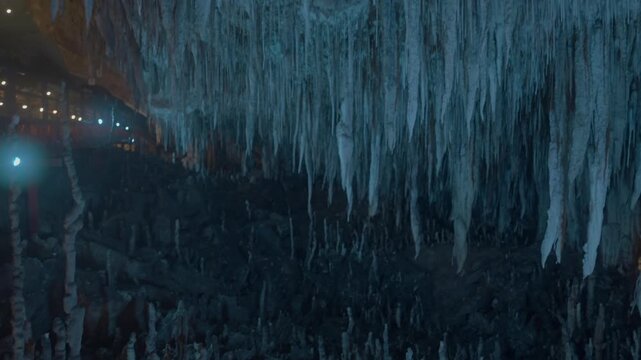 Panning left to right with a tilt up in a chamber with lots of small pinnacle like stalagmites and stalactites