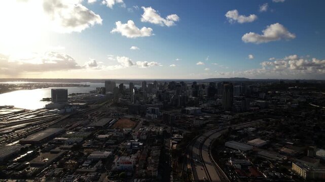 Drone flying north toward downtown San Diego at 6PM capturing a closer view of the skyline and buildings.