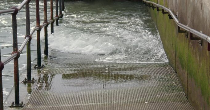 Mid shot of Incoming tide flooding the ramp to the beach at Shoreham harbour