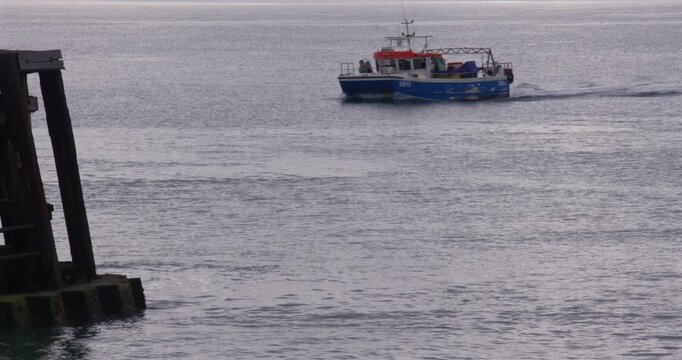 Wide shot of a fishing boat entering Shoreham Harbour