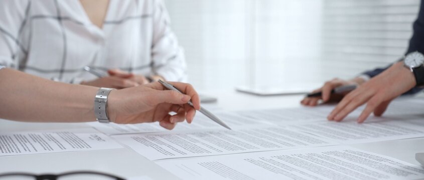 Business partners discussing financial contracts, reviewing legal documentation, and making important decisions at a corporate meeting or during a client consultation