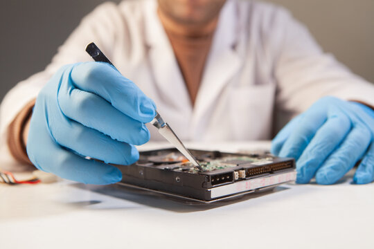 man repairing broken computer with screwdriver at home