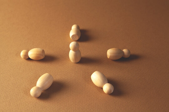 Wooden figures of people on a brown background. Conceptual image.