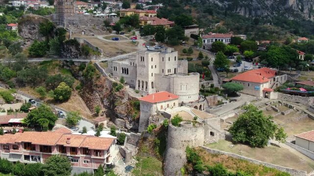 Panoramic aerial view flying over the historic Kruje Castle. Old fortress perched on a rocky hill in Albania, a famous tourist landmark