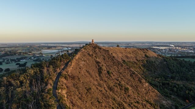 Valley Lake Conservation Park, Mount Gambier, South Australia at sunrise: 4K aerial drone footage of crater lake, forested hills, Centenary Tower, seasonal foliage and natural landscape near Blue Lake