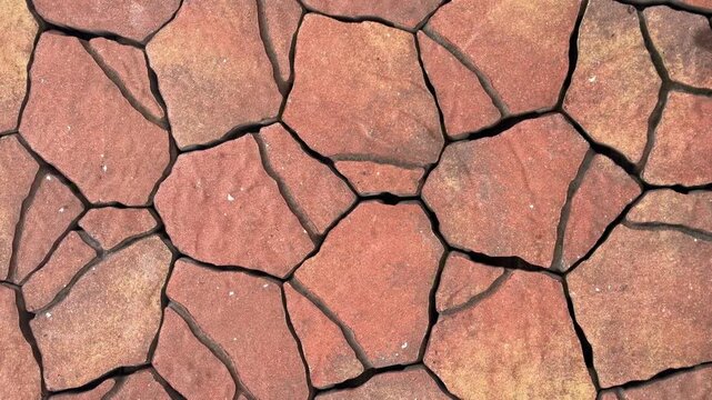 Red stone paving slabs with dark grout close up