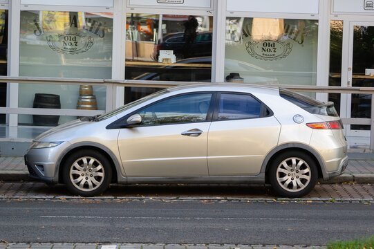 Side view of silver Honda Civic 8G futuristic hatchback car parked on street