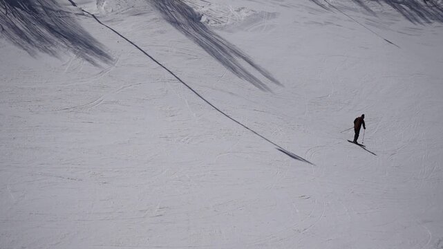 Slow motion skier and snowboarder riding on empty groomed slope in sunny winter day, anonymous people, alpine resort, clean white snow, ideal for sport, travel and lifestyle concepts