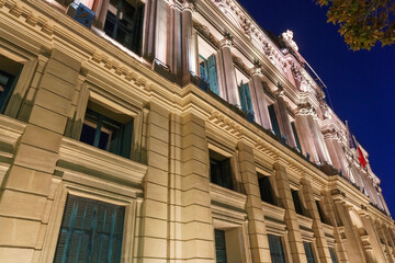 Obraz premium Historic architectural building in Cannes, France, featuring ornate columns, decorative elements, and illuminated facade against a night sky backdrop