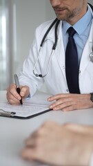 Doctor in white coat explaining test results to a patient using a digital tablet during a medical appointment. Medicine, healthcare and science concept © volha_r