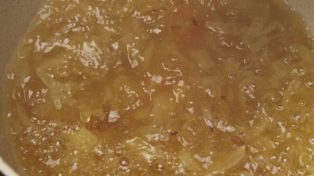 Close-up view of fresh carrot slices falling into a boiling vegetable soup. Perfect for emphasizing healthy eating and nutrition type stories