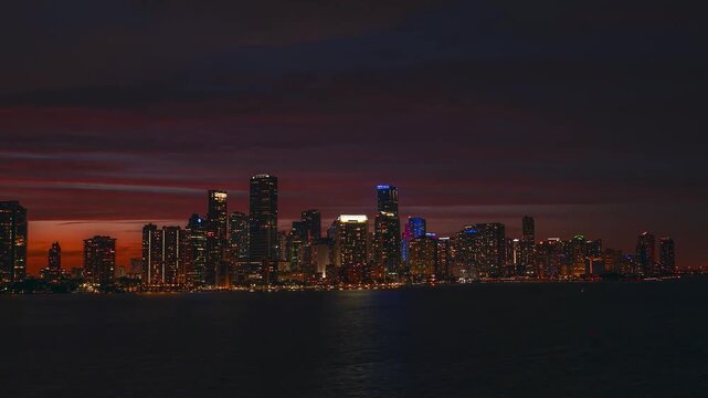 Stunning aerial timelapse capturing the transition from sunset to night over the Miami Beach skyline and turquoise Atlantic coast.