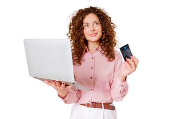 Naklejka premium Woman standing, holding a laptop and a credit card, thinking about online purchases, banking, or digital transactions
