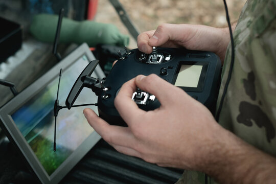 Military drone operation close up: controller in hands, live view tablet and FPV headset