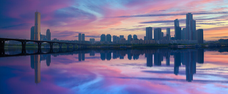 Dreamlike Han River twilight landscape in Seoul with skyscrapers and vibrant clouds reflected on the river water in South Korea