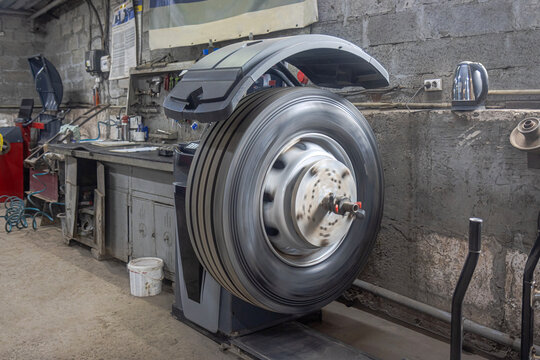 Balancing a truck wheel on an industrial tire changer in a workshop while in motion