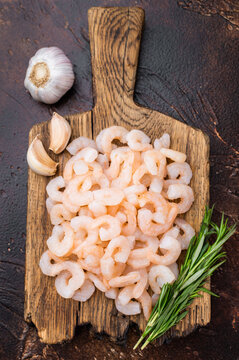 Baby shrimp pile on rustic cutting board, cocktail shrimp ingredient for salads, tapas, pasta and gourmet seafood recipes.