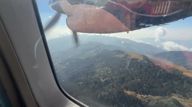 View from a small aircraft landing in Lukla airport, Nepal. Dramatic mountain scenery, dangerous short runway among high Himalayas, sunny day, adventure travel experience