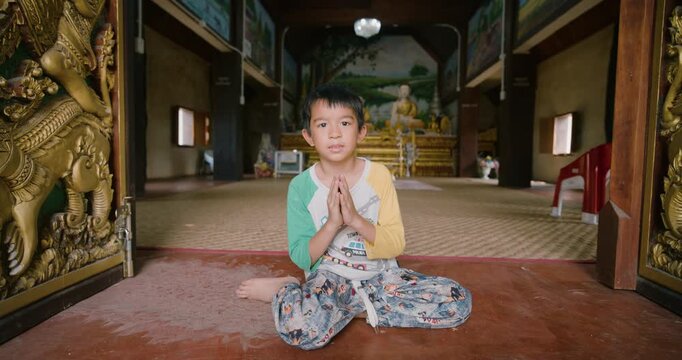 Little school boy enjoy respect in buddha statue pagoda temple travel in Bangkok Thailand
