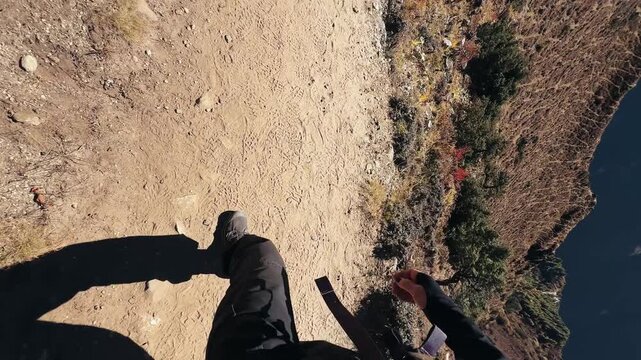 POV trekking in Himalayas, Nepal. First person view of walking feet on mountain trail with stunning valley and snowy peaks on the way to Everest Base Camp