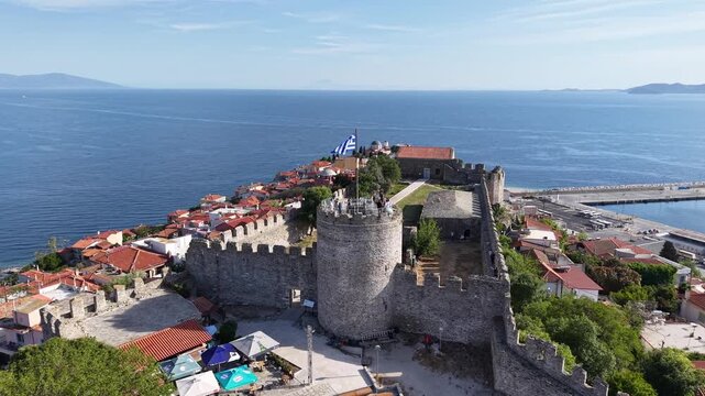 Aerial reveal from textured open water to a distant coastal horizon under a clear sky