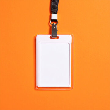 Blank office badge with empty name tag on vivid orange background, clean mock-up, minimal composition, modern corporate design