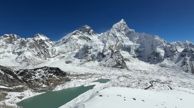 Smooth camera movement over Mount Everest and surrounding Himalayan peaks from Kala Patthar, Nepal. Panoramic view of valley, glacier and Everest Base Camp in clear sunny weather