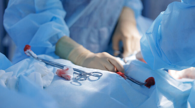 Surgical instruments and hands performing procedure on patient, med clinic banner