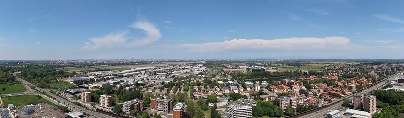 Obraz premium Cityscape Panorama: An expansive panorama showcases an urban landscape, blending residential and commercial areas, Peschiera Borromeo, Milan, Italy, 