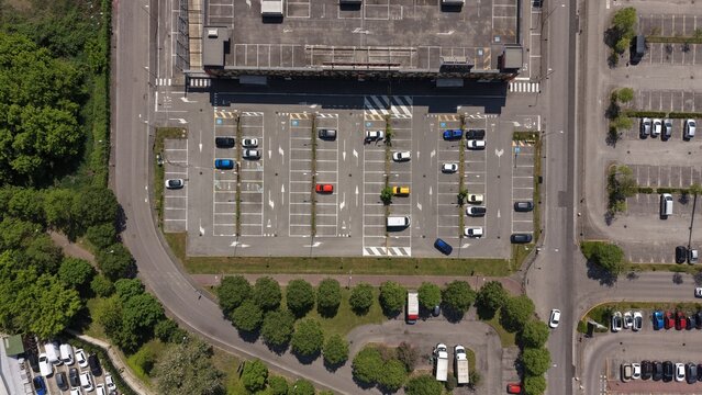 Parking Lot from Above: Aerial view of a well-organized parking area, filled with vehicles. The scene captures the organized structure and utilization of space.