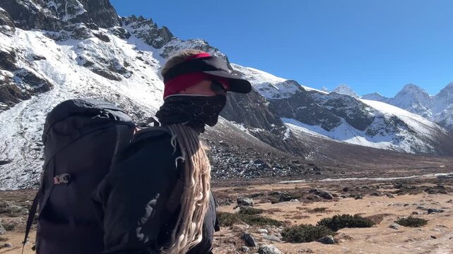 Young woman with dreadlocks hiking in the Himalayas on Everest Base Camp trek, Nepal. Backpacking traveler walking in mountains, adventure, freedom, travel lifestyle, nature