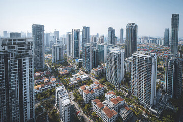 Fototapeta premium Modern city skyline with tall skyscraper buildings and residential houses under clear sky, showcasing urban architecture and cityscape in daylight