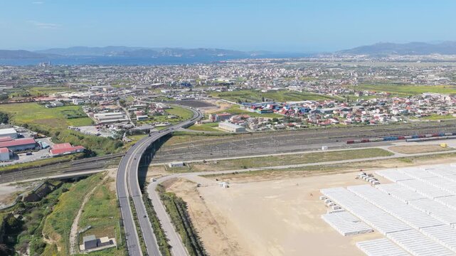 A comprehensive high-altitude aerial overview of a multi-modal transport and logistics network. 