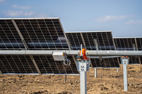 Solar farm tracker hardware showing PV modules, torque beam, galvanized pile, junction box, and alignment mechanism for renewable energy site view