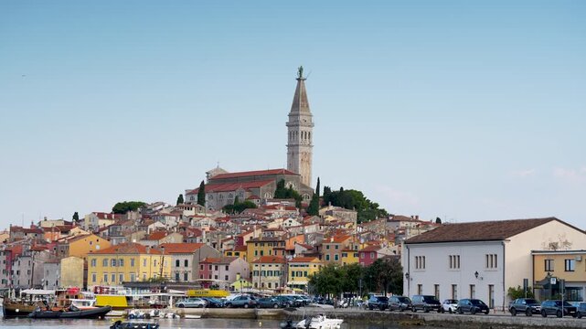 Rovinj, Croatia - August 16, 2025: Trieste&rsquo;s urban landscape features a majestic stone tunnel entrance flanked by historic yellow buildings, active traffic signals, and distant hillside monuments.
