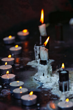 Burning Votive and Taper Candles with Melted Wax covered surface, moody background