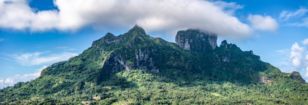 panoramic aerial view of green hilly landscape around the Mountain Range with Mount Otemanu and Mont Pahia located on Bora Bora Atoll, French Polynesia, Pacific Ocean