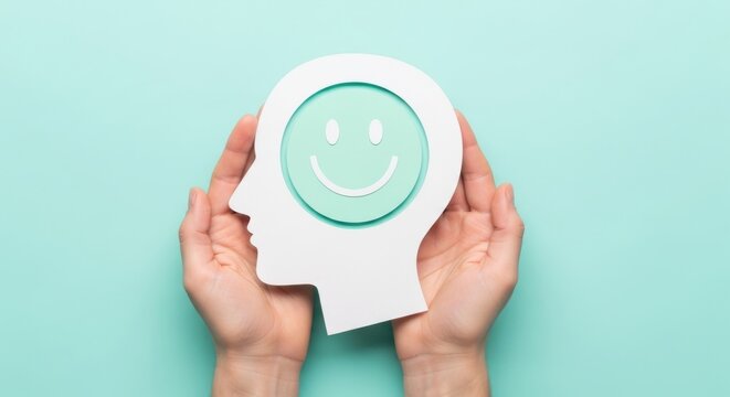 Mental health awareness concept, hands holding human head profile with happy smiley face, positive psychology and emotional wellness support