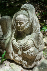 Fototapeta premium Stone monk statue at Mitaki-Dera temple in Hiroshima, Japan