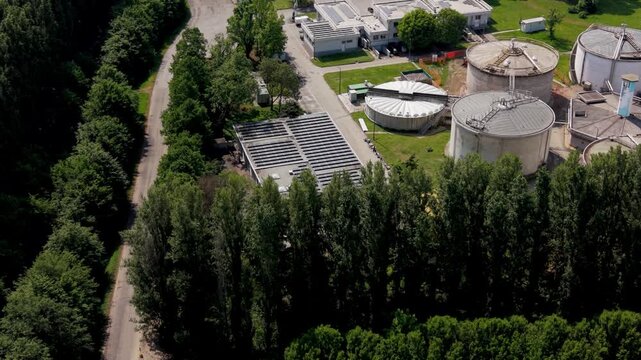 Sustainable Urban Ecosystem: An aerial perspective unveils a modern water treatment facility seamlessly integrated into a thriving green ecosystem.