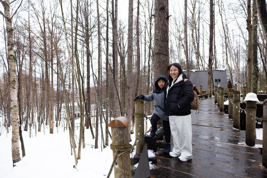 Asian mother and son travel. Traditional village. asian fat mother and family tourist Visiting in Furano, Traveler in Sweater sightseeing Ningle Terrace Cottages. landmark for attractions in Hokkaido